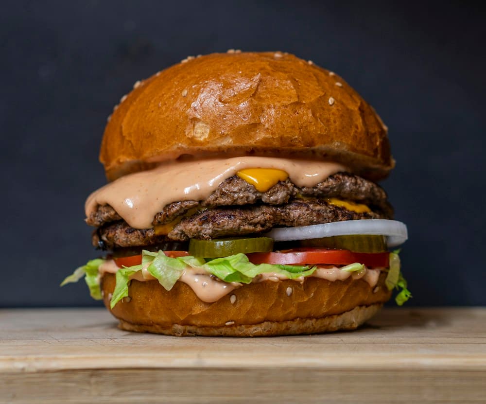 Fresh double smash burger with cheese, tomato and lettuce in a brioche bun